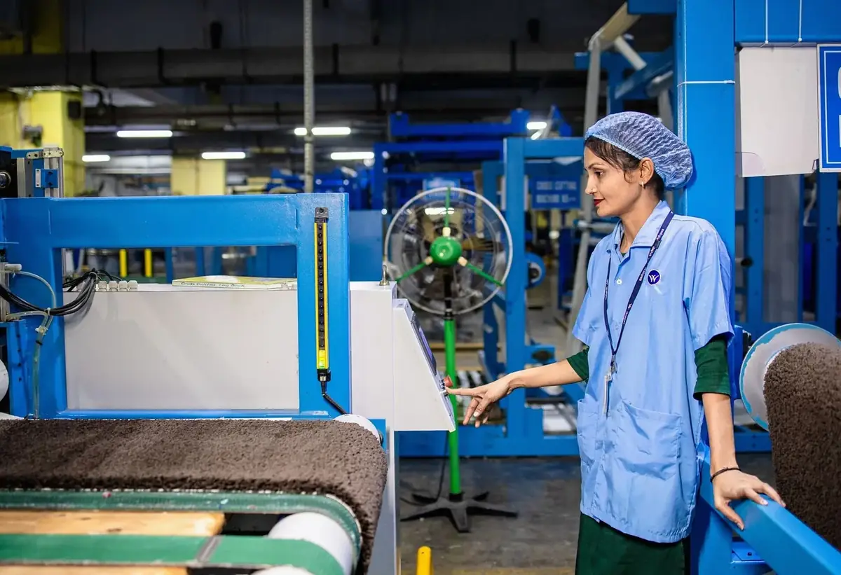 Factory worker pointing at production machinery on a plant floor